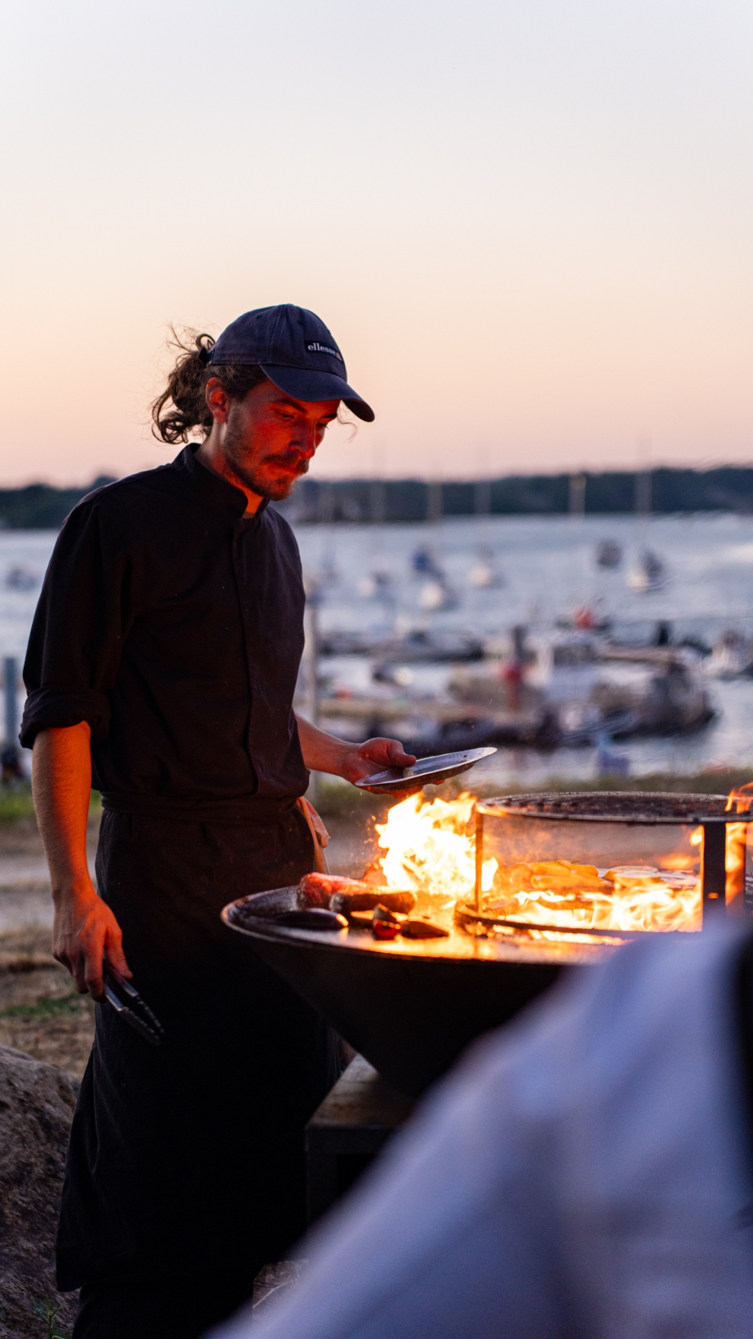 Chef cuisinant au feu de bois au coucher du soleil