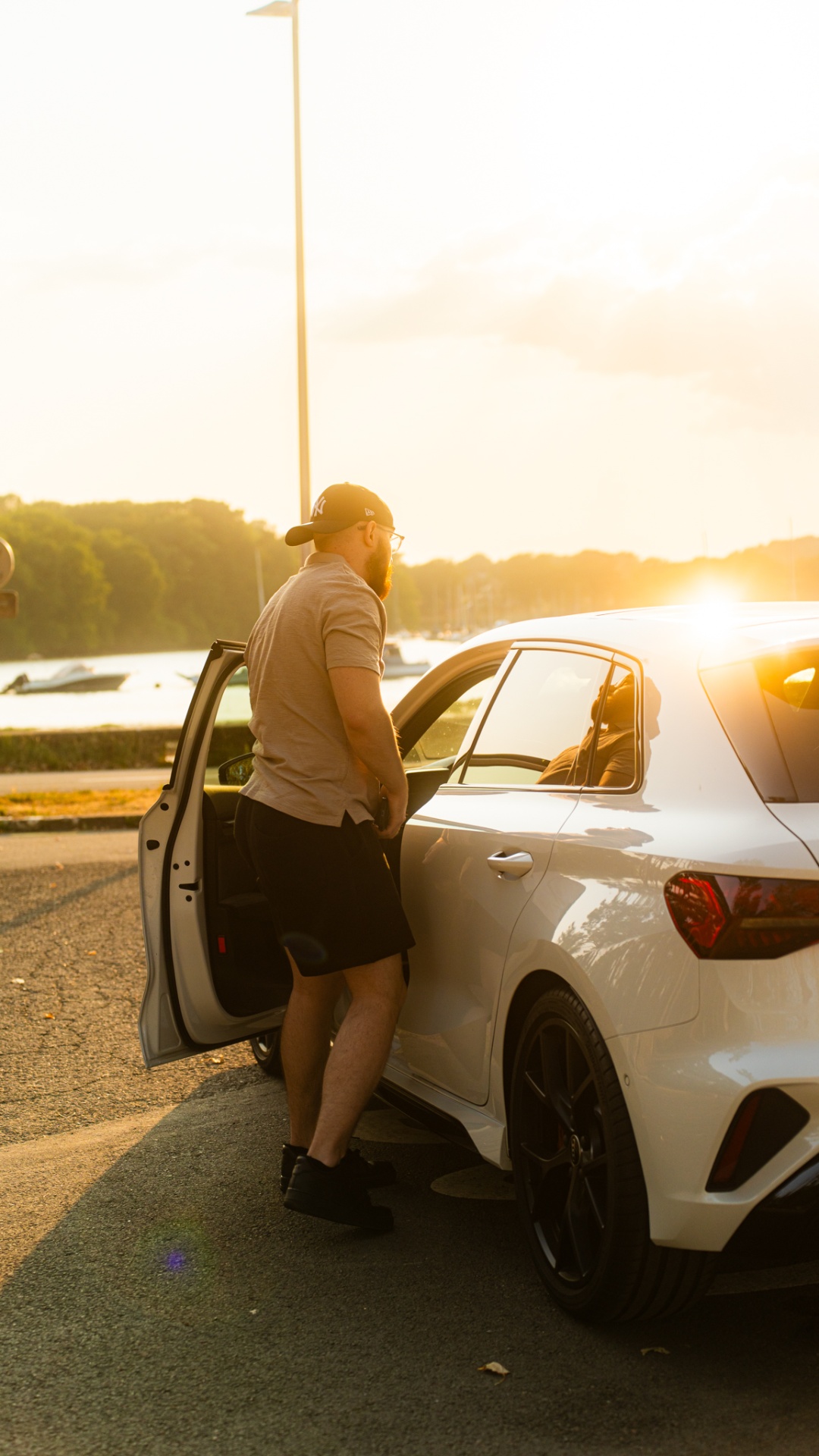 Audi RS3 blanche au coucher du soleil devant le port