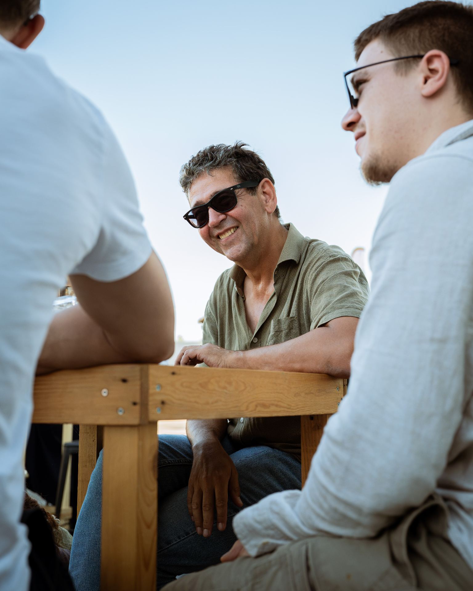 Invités discutant autour d'une table en bois lors d'un événement