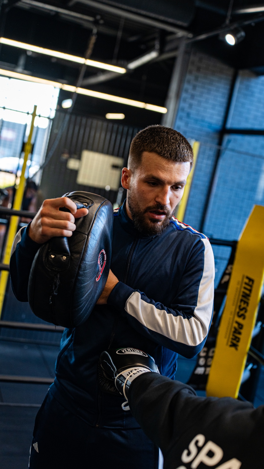 Boxeur travaillant les pattes d'ours avec son coach