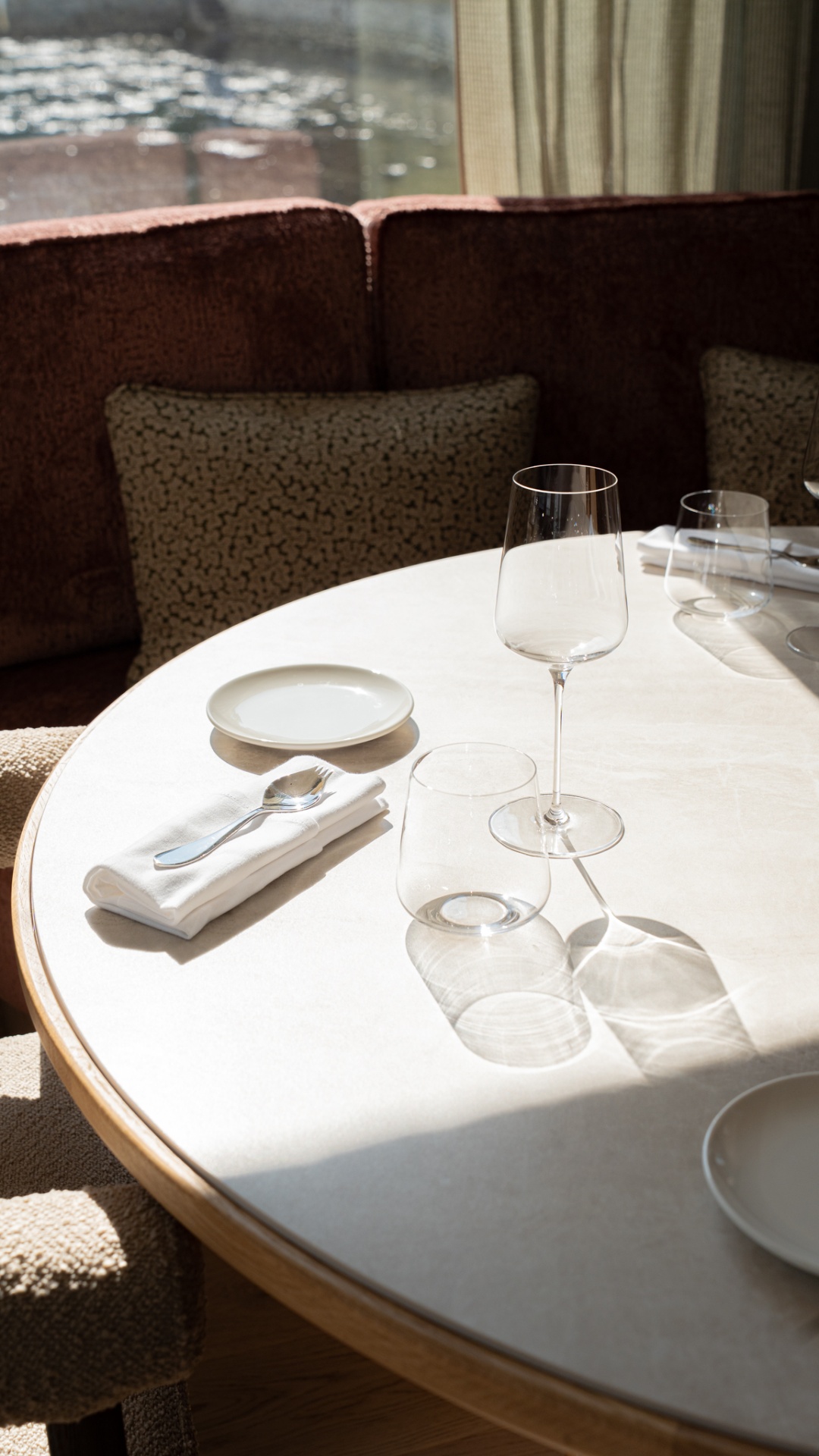 Table dressée avec verres et couverts face à la mer