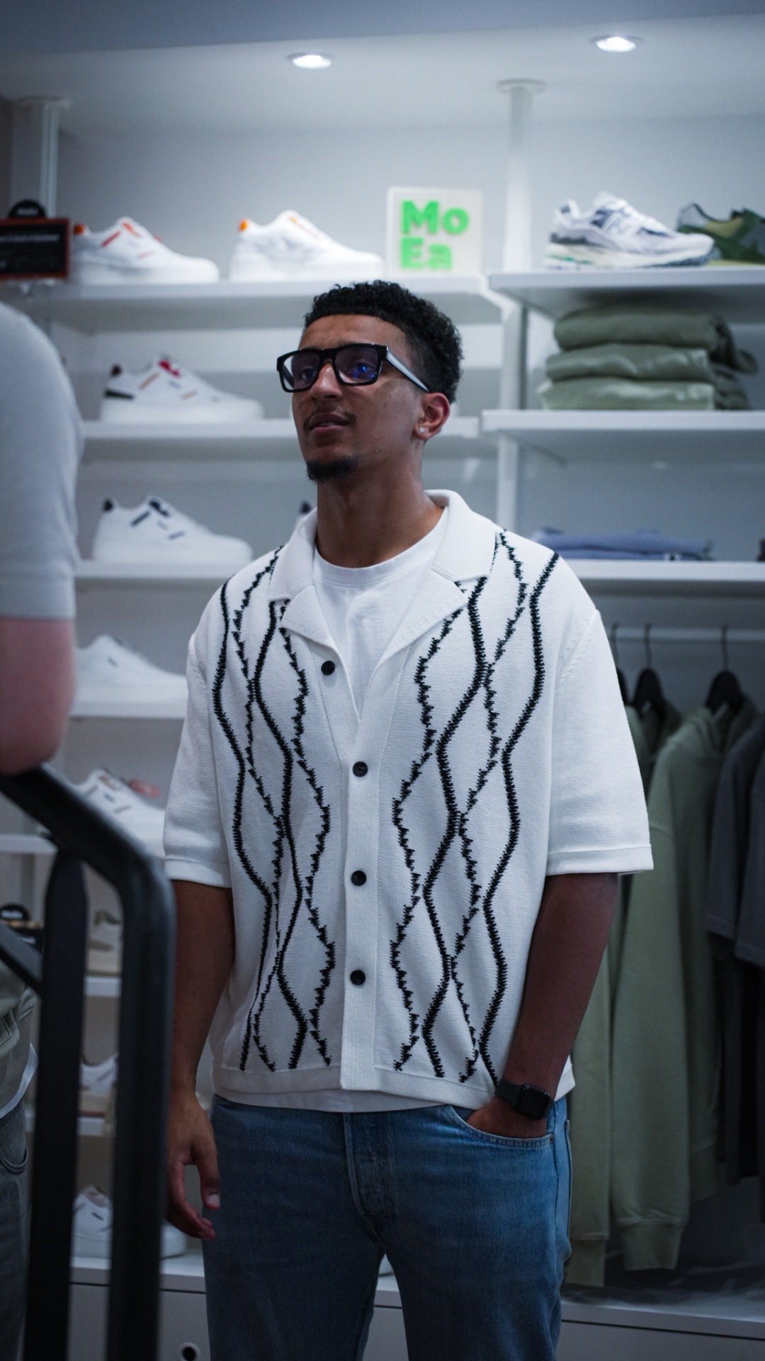Client en chemise blanche dans une boutique de sneakers