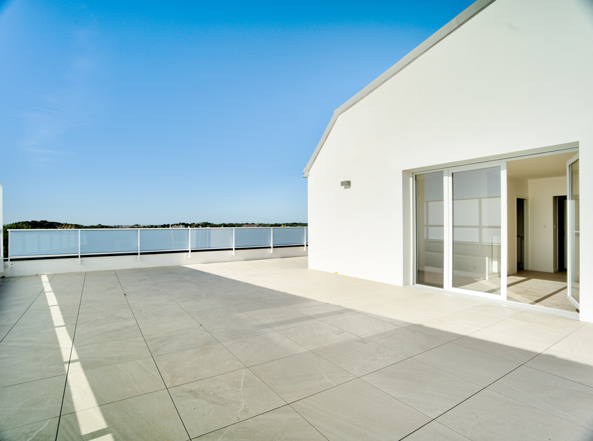 Terrasse avec garde-corps vitré et vue mer