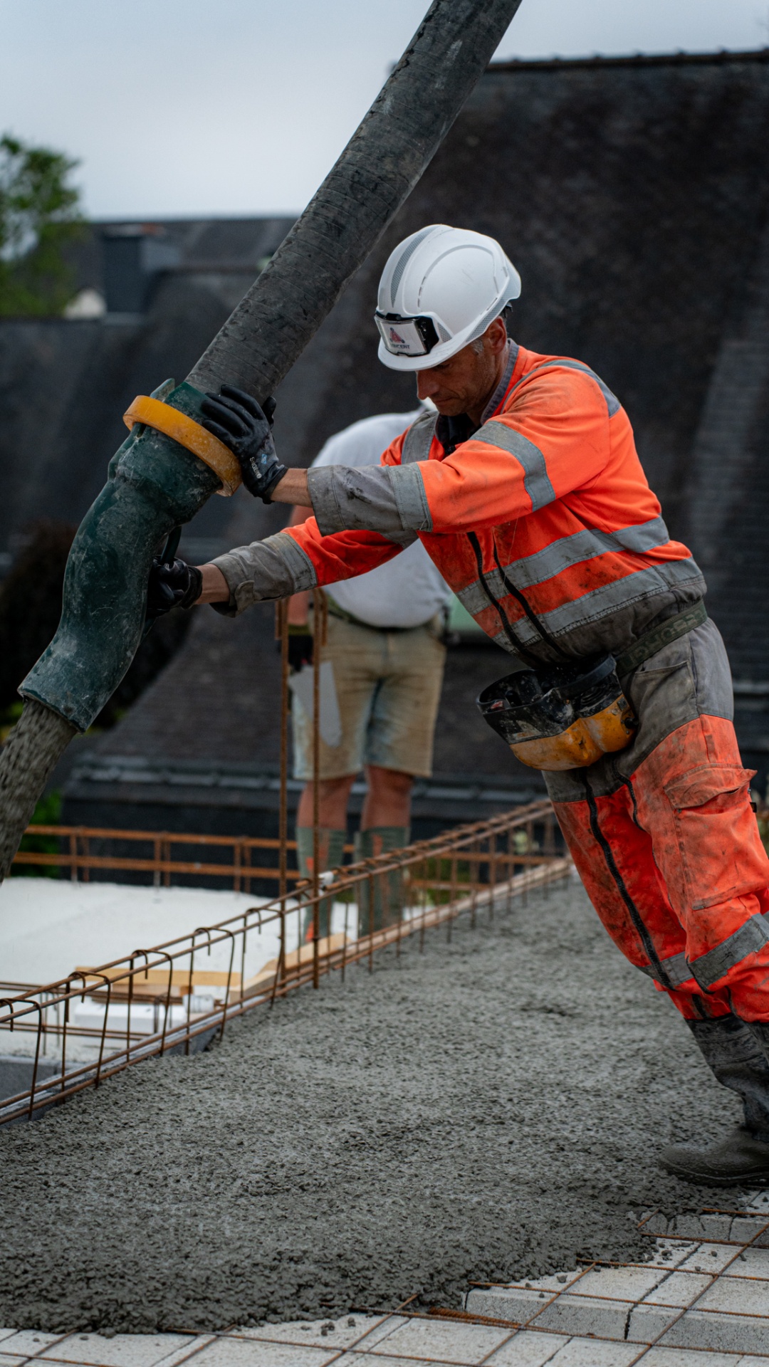Ouvrier Arvor Constructions coulant le béton au tuyau