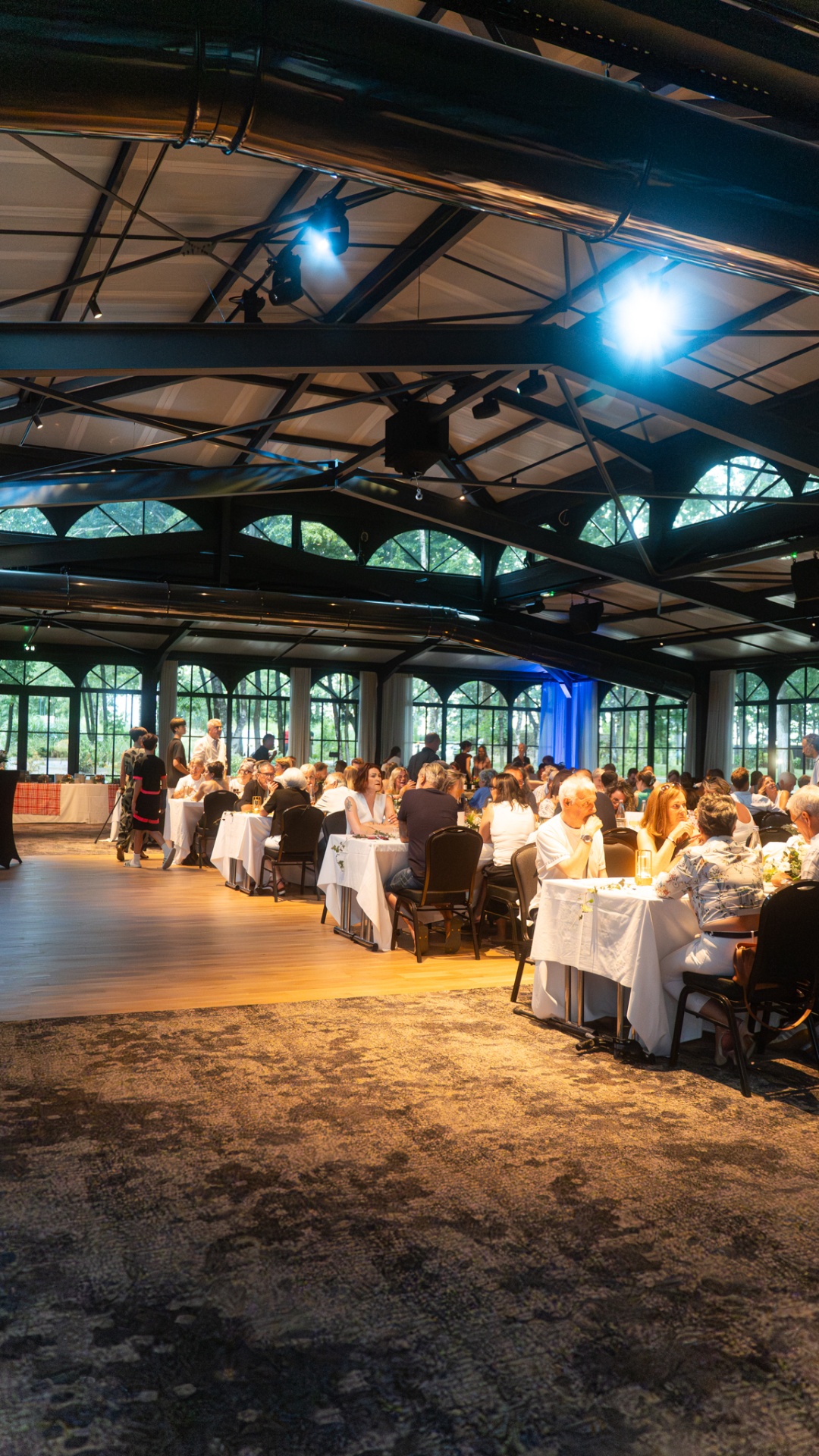 Salle de réception événementielle avec tables dressées sous verrière