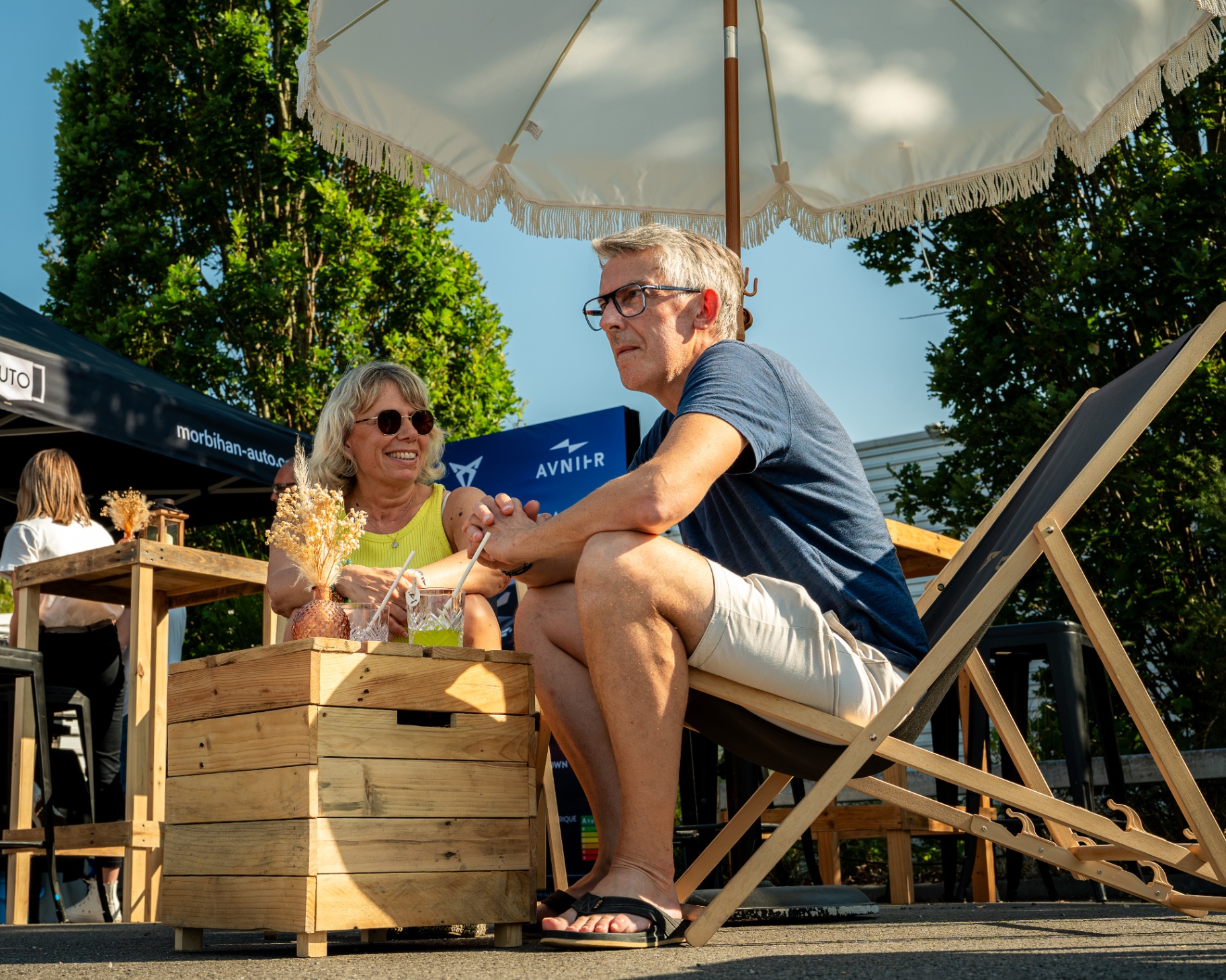 Couple installé en transats sous un parasol lors d'un événement Avnir / Morbihan Auto