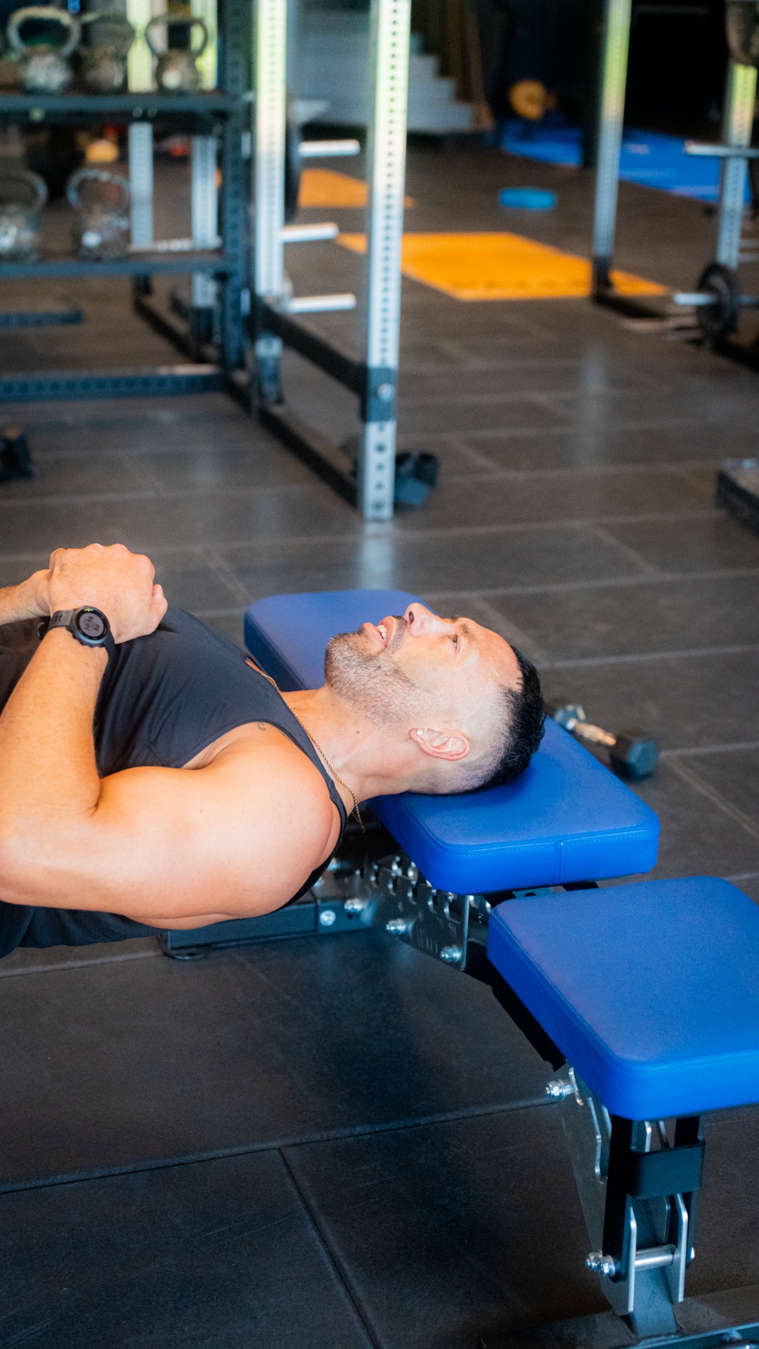 Athlète allongé sur un banc de musculation en salle de sport