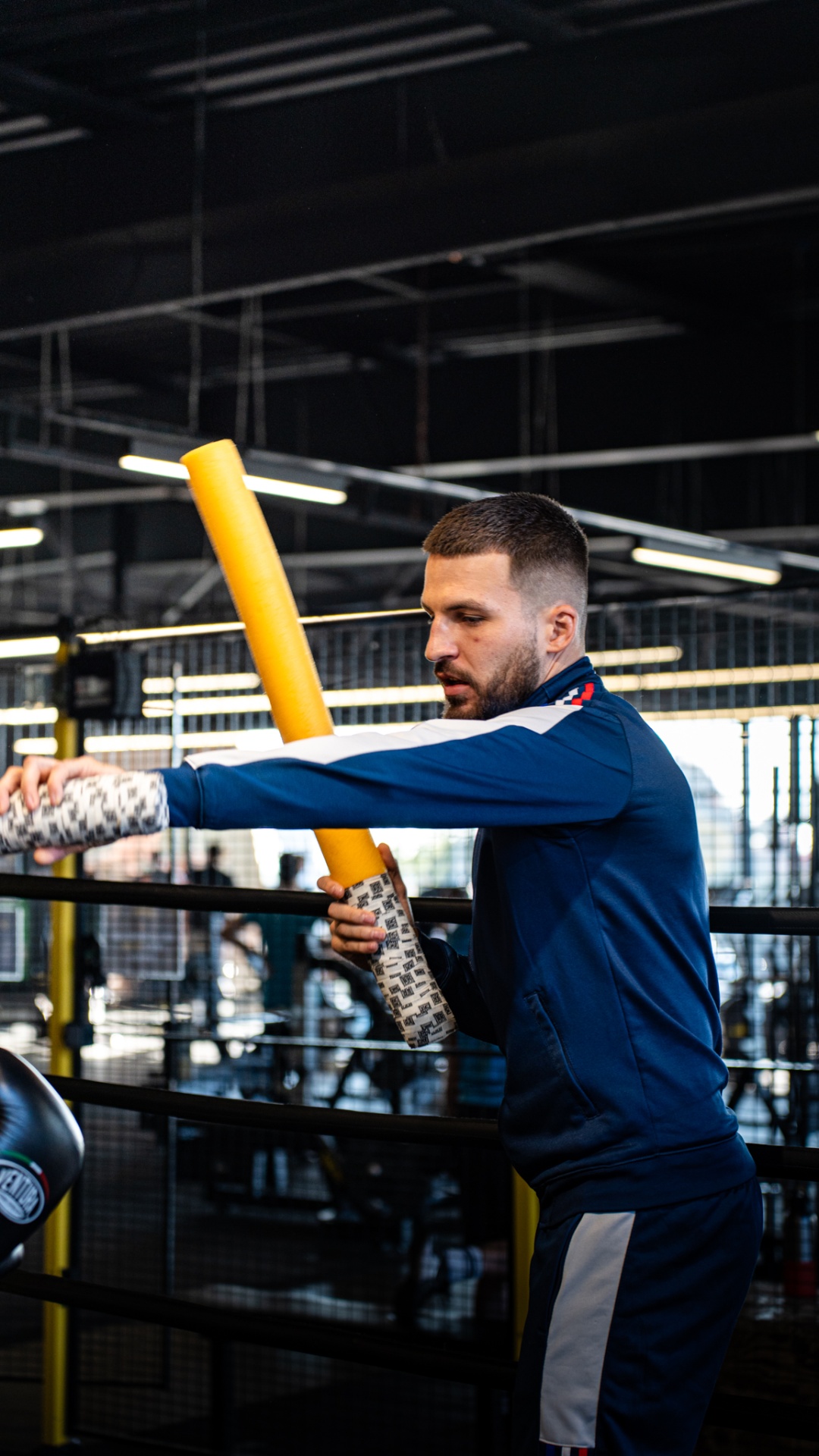 Boxeur en veste bleue s'échauffant sur le ring